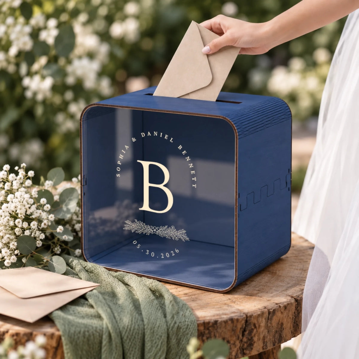 Personalized navy wedding card box with botanical monogram displayed at a wedding reception